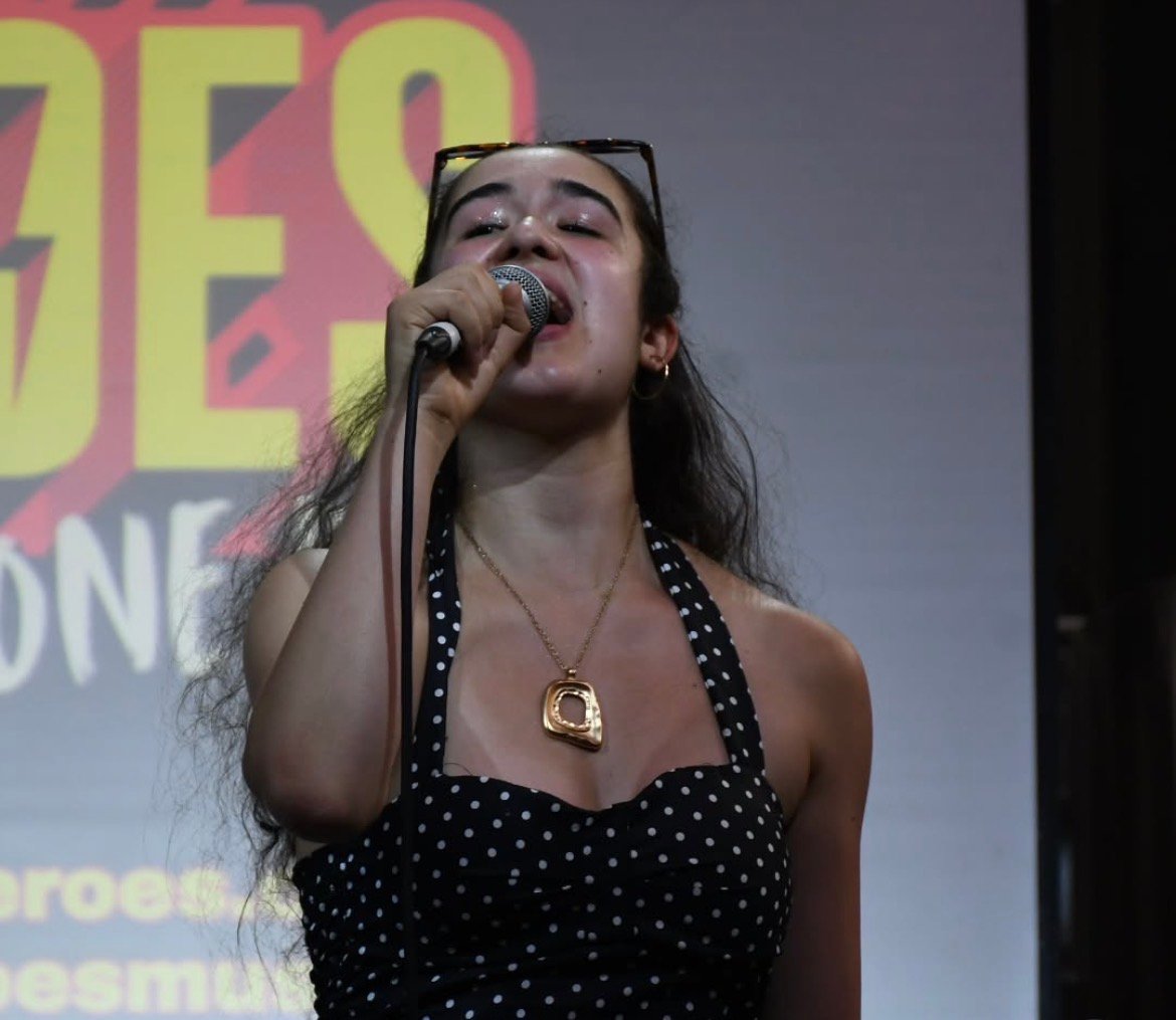 Rosie performing live, singing into a microphone